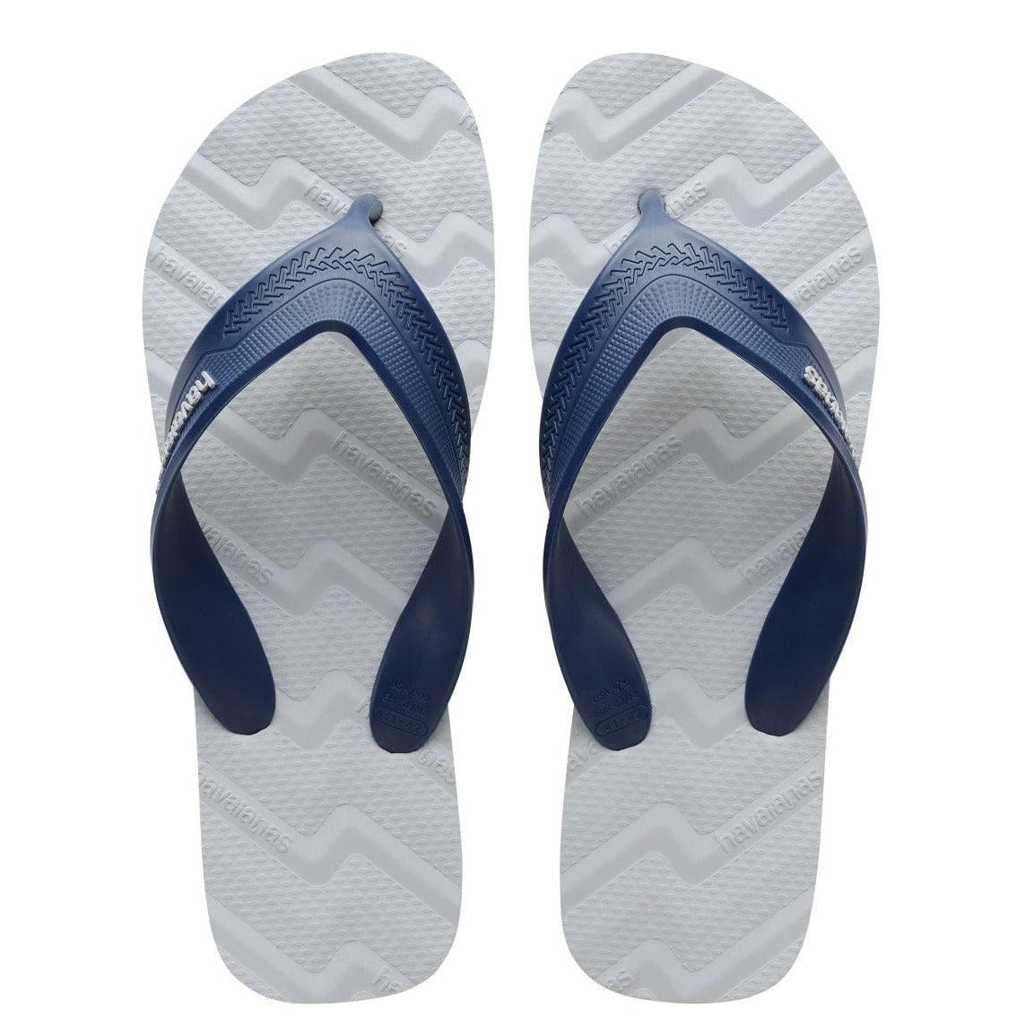 Par de chinelos Havaianas Track Waves cinza gelo com tiras azul marinho vistos de cima, sola texturizada e logo branco nas tiras